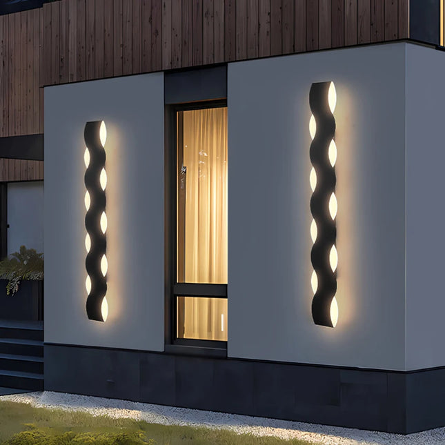 Deux appliques murales extérieures noires en forme de vague sur un mur de maison contemporaine