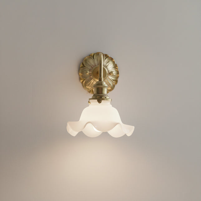 Applique murale fleur allumée diffusant une lumière dorée sur le mur