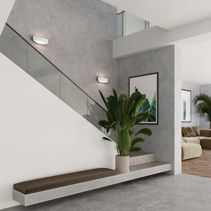 Applique murale Fluide blanc installée dans un intérieur épuré aux murs en béton ciré