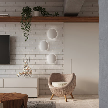 Trois appliques galet Ombre Douce blanches sur mur de briques dans un salon japandi