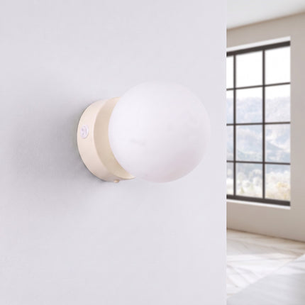 Applique Globe Solis beige, installée au mur dans un intérieur clair