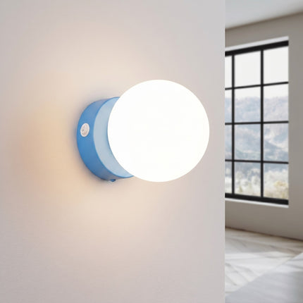 Applique Globe Solis bleu ciel allumée, halo doux du verre opalin