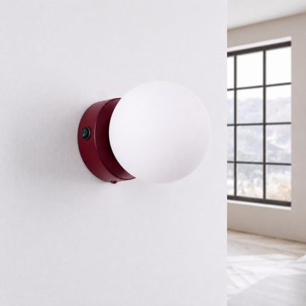 Applique Globe Solis bordeaux, installée au mur dans un intérieur clair