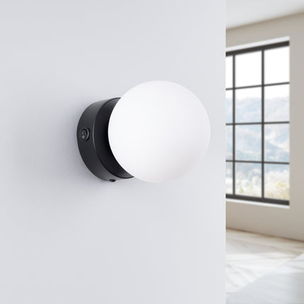 Applique Globe Solis noir, installée au mur dans un intérieur clair