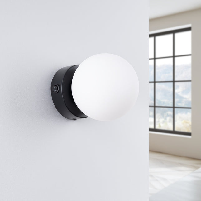 Applique Globe Solis noir, installée au mur dans un intérieur clair