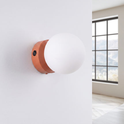 Applique Globe Solis ocre rouge, installée au mur dans un intérieur clair
