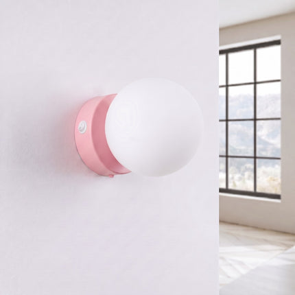 Applique Globe Solis rose, installée au mur dans un intérieur clair