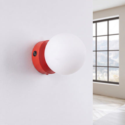 Applique Globe Solis rouge, installée au mur dans un intérieur clair