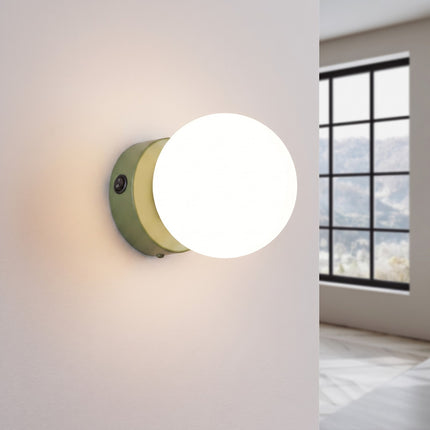 Applique Globe Solis vert olive allumée, halo doux du verre opalin