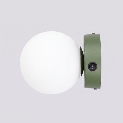 Applique Globe Solis vert olive sur fond coloré, vue de trois quarts