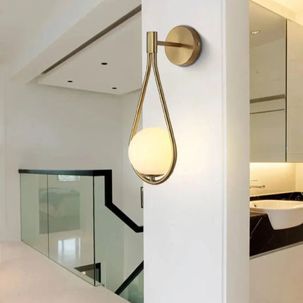 Applique murale goutte dorée à globe de verre opale dans un intérieur clair