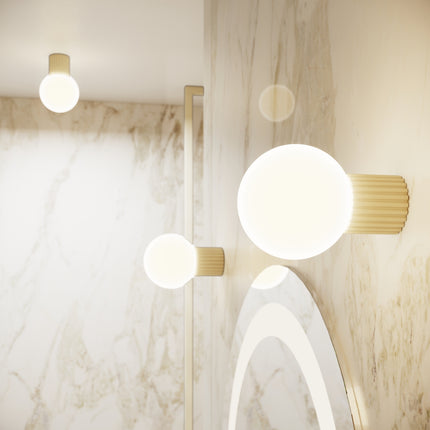 Applique murale Halo beige allumée dans une salle de bain en marbre et bois