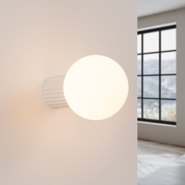 Applique Halo beige IP44 allumée, lumière douce diffusée sur un mur clair