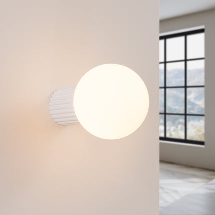 Applique Halo blanche IP44 allumée, lumière douce diffusée sur un mur clair