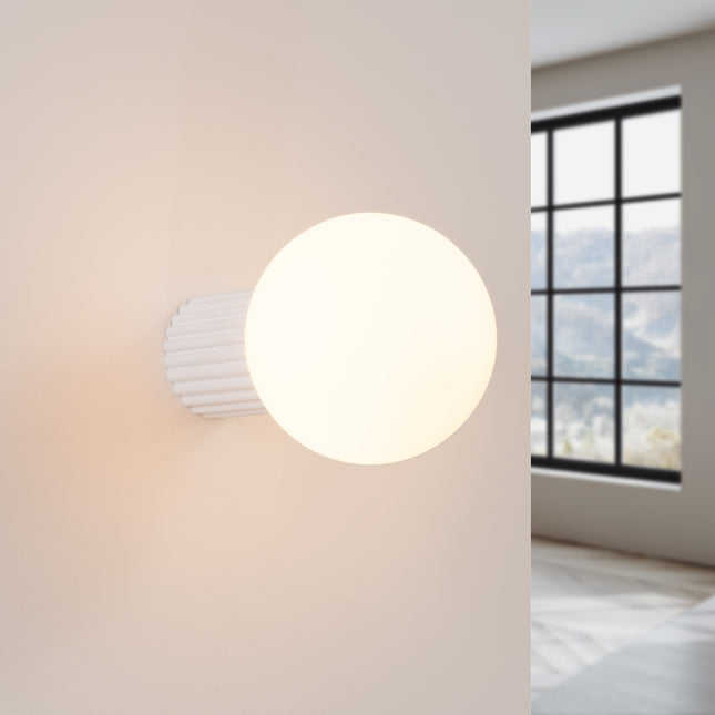 Applique Halo blanche IP44 allumée, lumière douce diffusée sur un mur clair