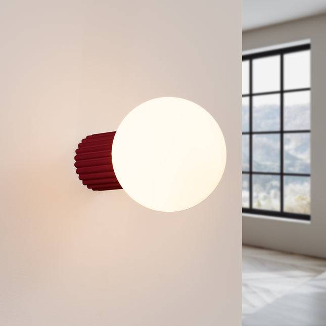 Applique Halo bordeaux IP44 allumée, lumière douce diffusée sur un mur clair