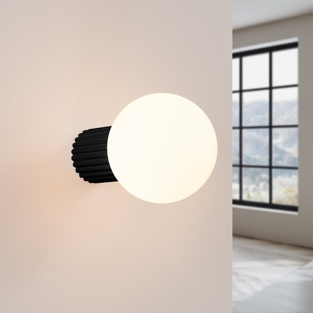 Applique Halo noire IP44 allumée, lumière douce diffusée sur un mur clair