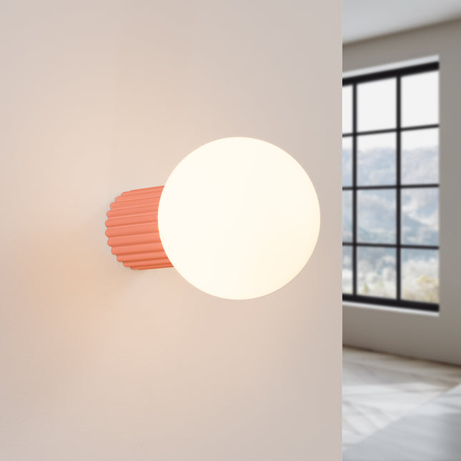 Applique Halo pêche IP44 allumée, lumière douce diffusée sur un mur clair