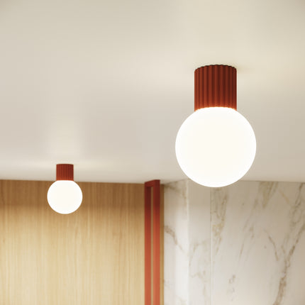 Plafonnier et applique Halo rouge ocre allumés diffusant une lumière chaleureuse