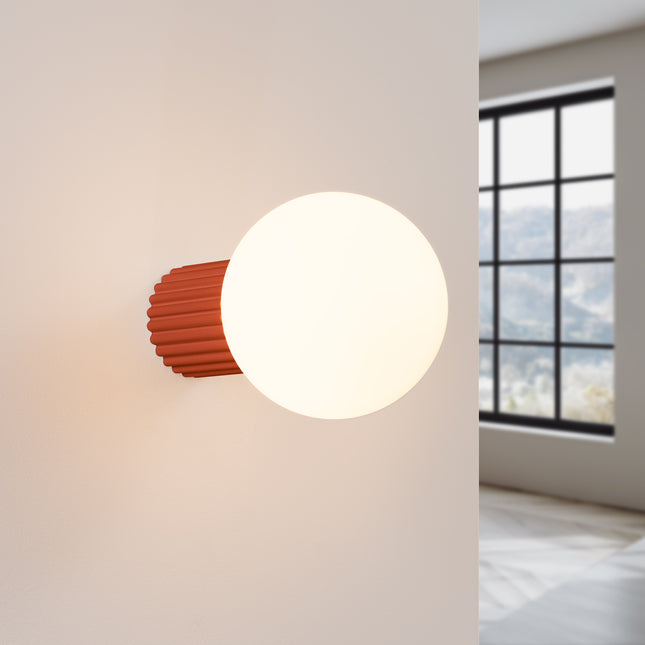 Applique Halo rouge ocre IP44 allumée, lumière douce diffusée sur un mur clair