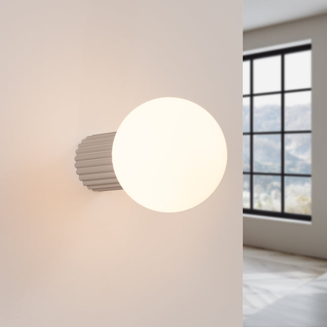 Applique Halo taupe IP44 allumée, lumière douce diffusée sur un mur clair