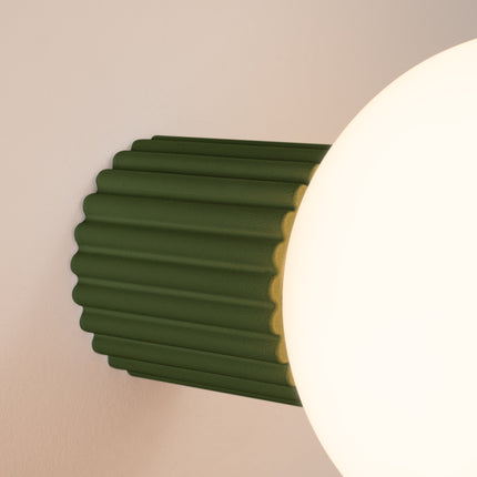 Gros plan sur les nervures du socle aluminium vert olive et le globe en verre de l'applique Halo
