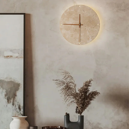 Applique horloge en travertin sur un mur brut beige, décor japandi avec pampa et vase