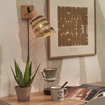 Applique murale Java bambou orientable au-dessus d'un bureau, abat-jour tressé noir et naturel allumé dans une ambiance japandi