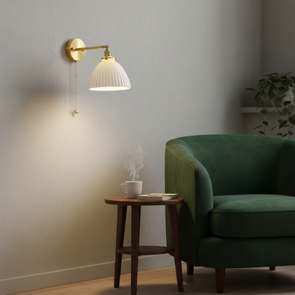 Applique murale laiton et céramique près d'un fauteuil vert dans un salon cosy au coin lecture