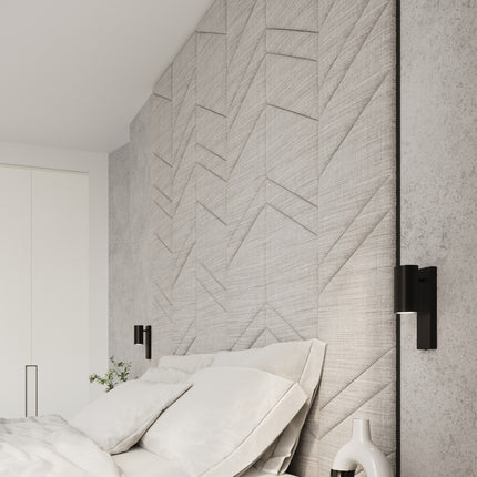 Détail de l'applique noire allumée en chevet dans une chambre au décor texturé beige