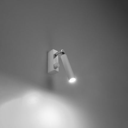Applique liseuse acier blanc allumee projetant un faisceau de lecture precis sur un mur