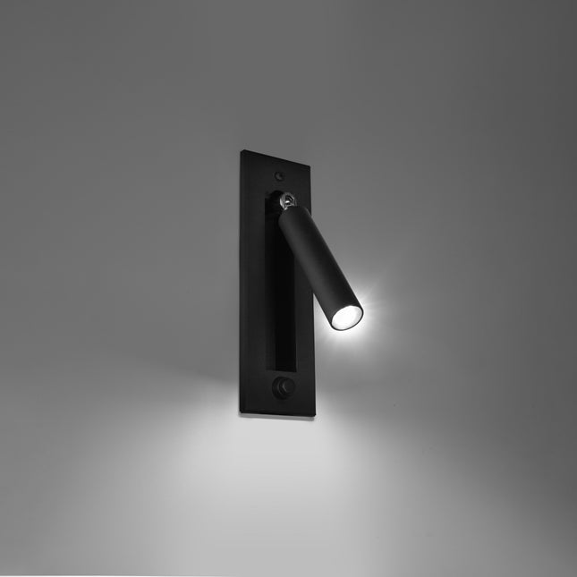 Applique liseuse noire allumée diffusant un faisceau de lecture ciblé sur un mur gris