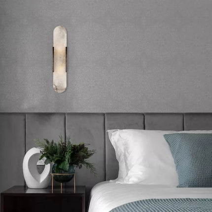 Applique en marbre naturel à côté d'une tête de lit capitonnée grise dans une chambre contemporaine