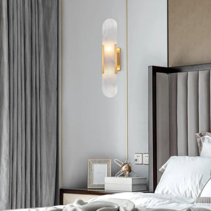 Applique en marbre naturel dorée au-dessus d'un chevet dans une chambre, lumière douce et chaleureuse