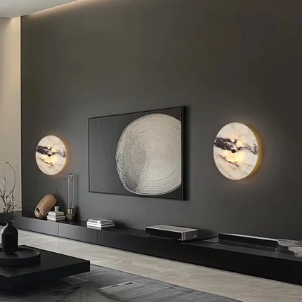 Deux appliques en marbre naturel disposées de part et d'autre d'un cadre sur un mur sombre de salon