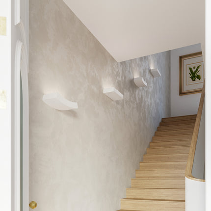 Appliques céramique blanche éclairant une cage d'escalier aux murs clairs