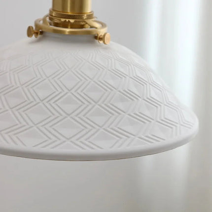 Détail de l'abat-jour en céramique blanche orné d'un motif géométrique en losanges