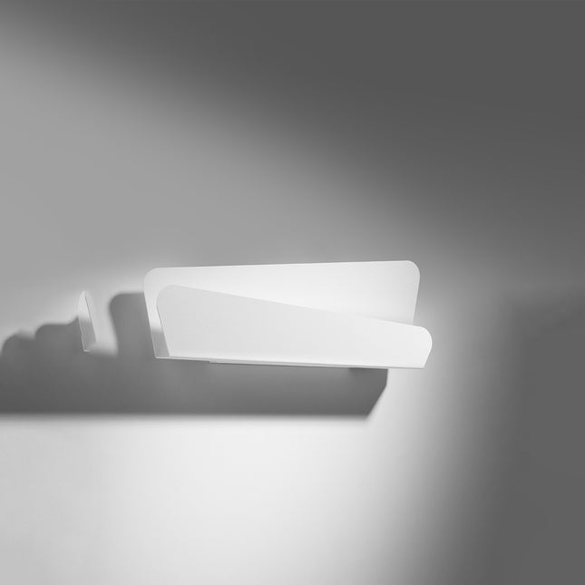 Applique murale en acier blanc mat, design horizontal, allumée contre un mur clair