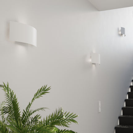 Appliques murales Arc blanches installees le long d'une cage d'escalier claire
