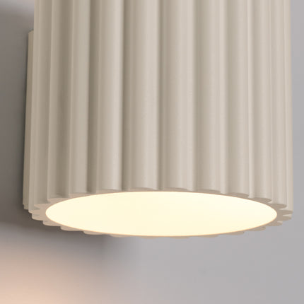 Détail de l'applique Aura beige cannelée, faisceau lumineux dirigé vers le bas