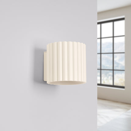 Applique murale Aura beige installée sur un mur clair près d'une fenetre