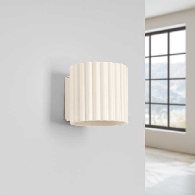 Applique murale Aura beige installée sur un mur clair près d'une fenetre