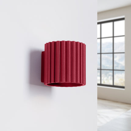 Applique murale AURA bordeaux fixée sur un mur blanc de chambre lumineuse