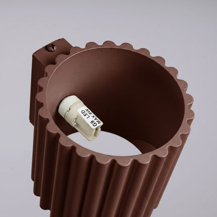 Applique murale Aura cannelée aluminium brun chocolat, vue sur fond coloré