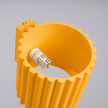Applique murale Aura cannelée aluminium jaune ambré, vue sur fond coloré