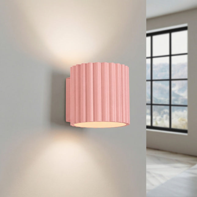 Aura fluted aluminium wall light in powder pink, light on