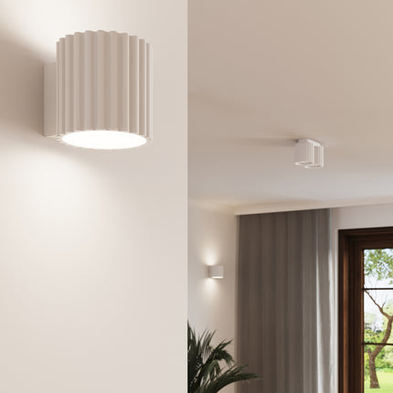Détail de l'applique murale Aura cannelée blanche dans un couloir épuré style japandi