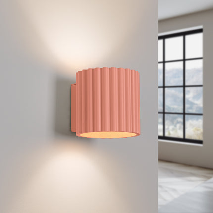 Applique murale Aura pêche allumée diffusant deux halos de lumière vers le haut et le bas