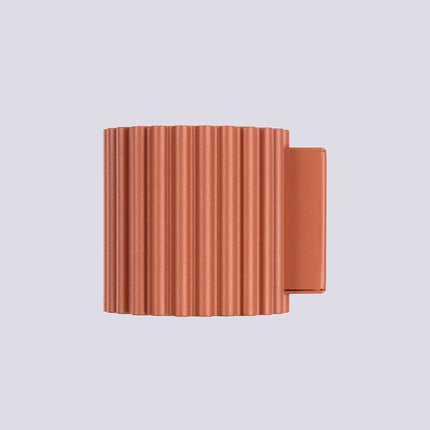 Gros plan sur l'intérieur et la platine de fixation en aluminium de l'applique Aura rouge ocre