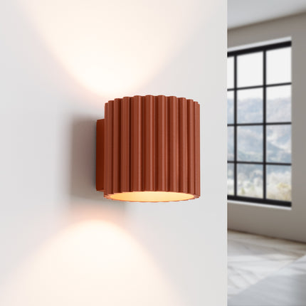 Applique murale Aura rouge ocre allumée diffusant un éclairage bi-directionnel vers le haut et le bas